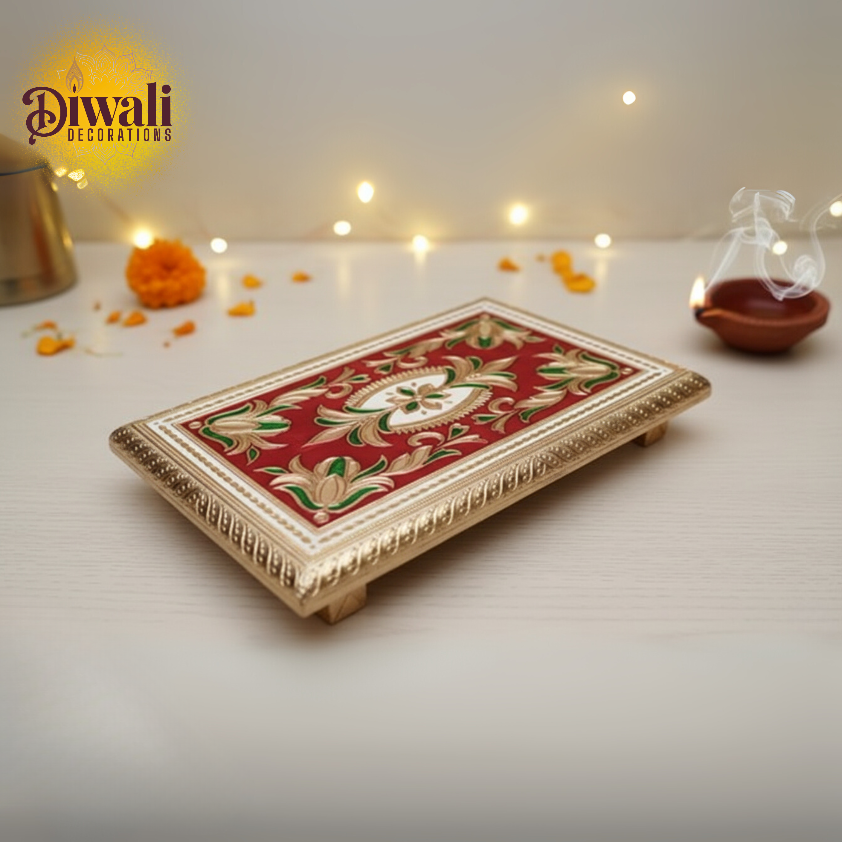 Decorative tray with floral patterns on a Diwali-themed setting with lights and small objects.